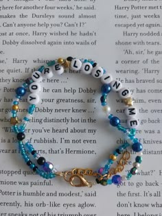 a bracelet with words and charms on it sitting on top of an open book page