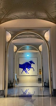 the entrance to an office building with a horse painting on it's wall and ceiling