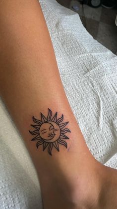 a person with a tattoo on their arm that has the sun and moon in it