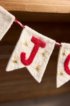 a red and white banner with the letter j on it hanging from a wooden shelf