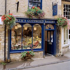 a store front with flowers on the windows