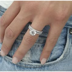 a close up of a person's hand with a diamond ring on their finger