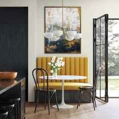 a dining room with yellow chairs and a white table