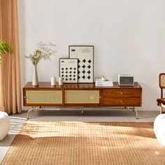 a living room with white walls and wooden furniture in the center, along with an area rug on the floor