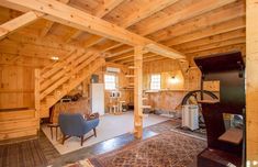 a living room filled with furniture and wooden walls