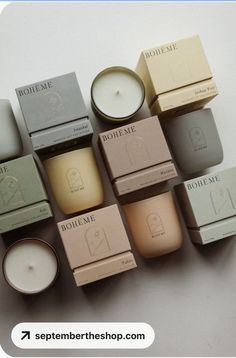 many different types of candles sitting next to each other on top of a white surface