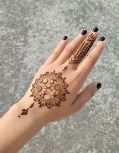 a woman's hand with henna tattoos on it