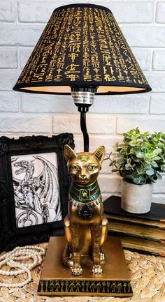 a golden dog lamp sitting on top of a table next to a potted plant