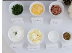 several small bowls filled with different types of cheese and seasoning on top of a table