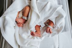 a baby wrapped in a white blanket is laying on top of a clear box with its head resting on it's side