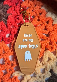 there are my spook - heys keychain on top of a crocheted blanket