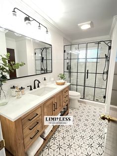 a bathroom with two sinks and a large mirror above the sink is decorated in black and white tile