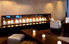 a living room filled with lots of furniture and lit candles on the wall above it