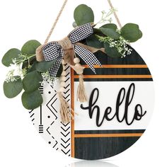 a wooden sign that says hello hanging from a rope with greenery and leaves on it