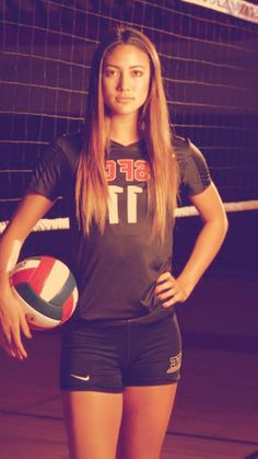 a female volleyball player is posing for a photo