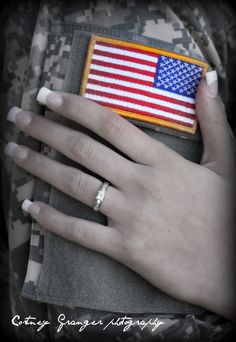 a woman's hand holding an american flag patch in her pocket with the ring on it