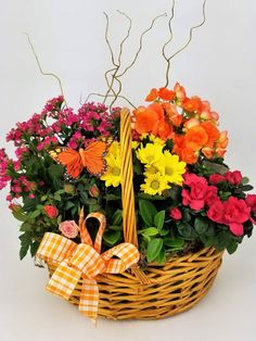 a basket filled with lots of different colored flowers and butterflies on top of each other