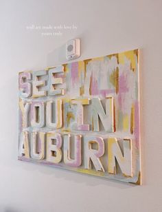 an art piece with the words see you in auburn on it hanging on a wall