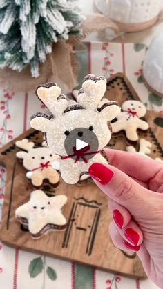 a person holding up some cookies with reindeers on them