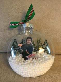 a christmas ornament with a photo on it and snow balls in the bottom