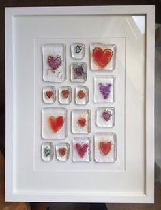 a white frame with some hearts in it on a table next to a stuffed animal