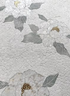 white flowers and leaves on a mosaic tile flooring design with gold accents in the center