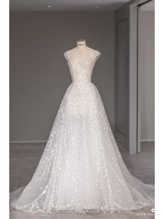 a white wedding dress on display in a room