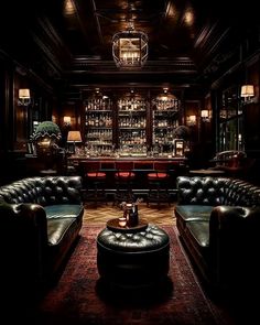 a dimly lit bar with leather couches and stools