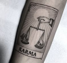 a tattoo on the arm of a person holding a scale