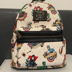 a white backpack with captain america designs on the front and back sides, sitting on a table