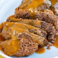 meatloaf covered in gravy on a white plate