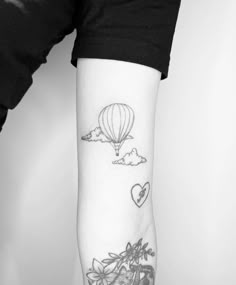 a woman's arm with a tattoo on it and a hot air balloon in the sky