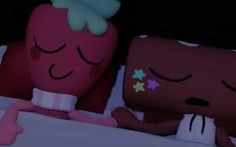 two stuffed animals laying on top of a bed next to each other in the night