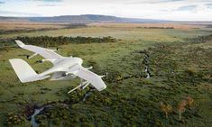 an airplane flying over a lush green field