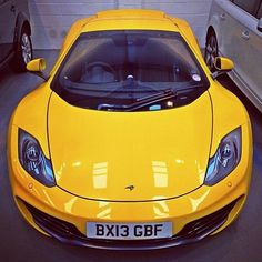 a yellow sports car parked in a garage