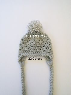 a crocheted hat with the number one light gray written in white on it