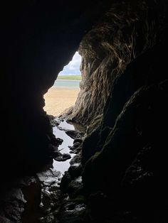 the entrance to a cave with water running through it