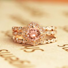 a pink diamond ring sitting on top of a piece of paper