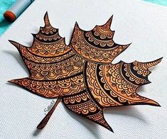 an intricately designed leaf on a piece of paper