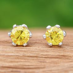 As the jewels of the jolly and successful, citrine stones crown every soul with an aura of happiness, just like these sterling silver stud earrings presented by Wadarat Supasirisuk. Crafted in Thailand, the design features an elegant prong setting in which the yellow gems rest gracefully, displaying a refined faceted finish and round cut. Yellow Birthstone Jewelry Round Cut, Yellow Round Earrings With Prong Setting, Yellow Round Cubic Zirconia Earrings, Fine Jewelry Yellow Earrings For Gift, Yellow Fine Jewelry Earrings For Gift, Yellow Sterling Silver Jewelry Set With Matching Earrings, Classic Yellow Earrings As Gift, Classic Yellow Earrings For Gift, Silver Citrine Earrings For Gift