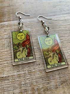 the sun tarot card earrings on a wooden table