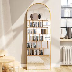 an arched wooden book shelf with books on it next to a radiator in a living room