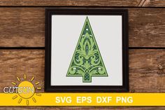 a green christmas tree cut out in the shape of a sun on a wooden background