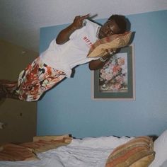 a man jumping in the air on top of a bed