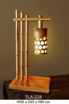 a lamp made out of bamboo sticks on top of a wooden table