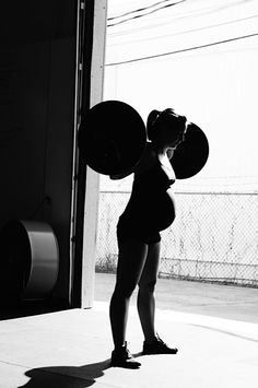 black and white photograph of a woman holding two large discs