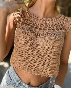 a close up of a woman wearing a top with crochet on the back