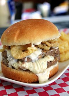 a cheeseburger with onion rings on a plate