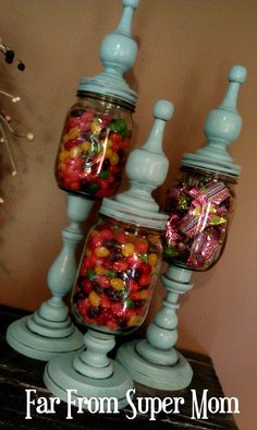 three jars filled with candy sitting on top of a table next to each other and the words far from super mom above them