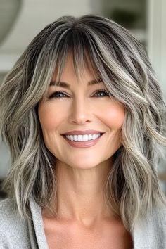 Save this pin for the best medium-length layered haircuts for women over 50. This shaggy cut celebrates your natural hair color. It’s especially flattering for women with salt-and-pepper hair, as the layers allow the blend of greys and silvers to shimmer, almost like highlights. Medium Length Gray Hair With Layers Over 50, Color For Gray Hair Highlights, Natural Grey Hair With Highlights, Highlights On Grey Hair, Salt And Pepper Hair Women, Grey Blending Hair, Cute Mom Haircuts, Shaggy Cut, Grey Hair With Bangs